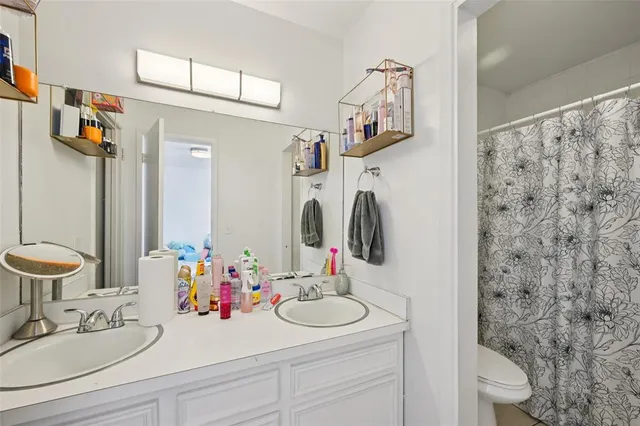a bathroom with a sink vanity mirror and toilet