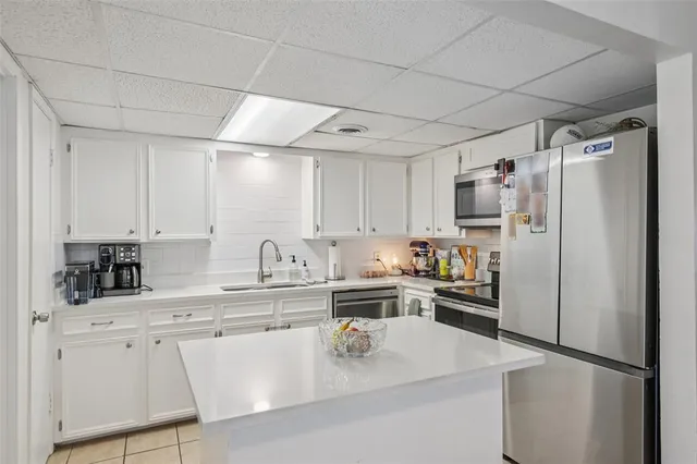 a kitchen with appliances a sink and cabinets