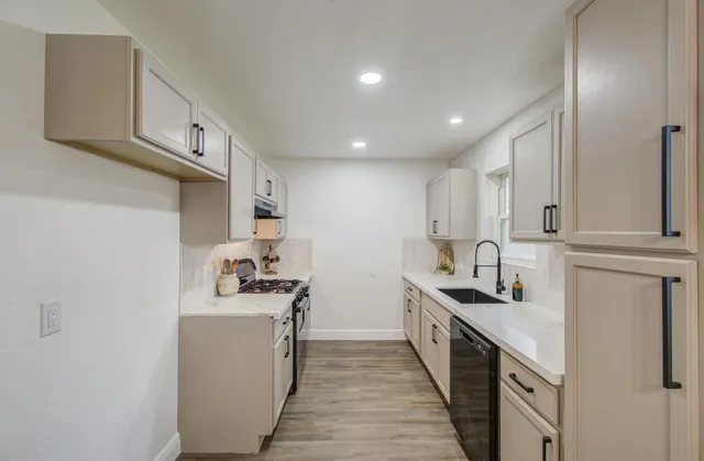 a kitchen with stainless steel appliances a sink stove and cabinets