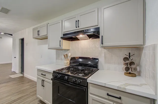 a kitchen with stainless steel appliances granite countertop a stove and a microwave