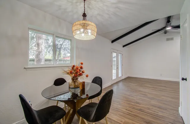 a view of a dining room with furniture and chandelier