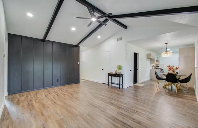 a view of a hallway with wooden floor and a potted plant
