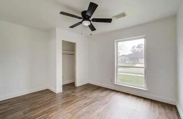 a view of room with wooden floor and windows