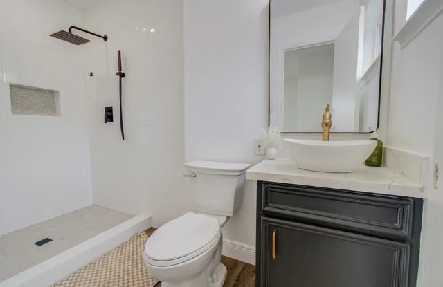 a bathroom with a sink a toilet and shower