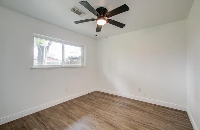 wooden floor in an empty room with a window