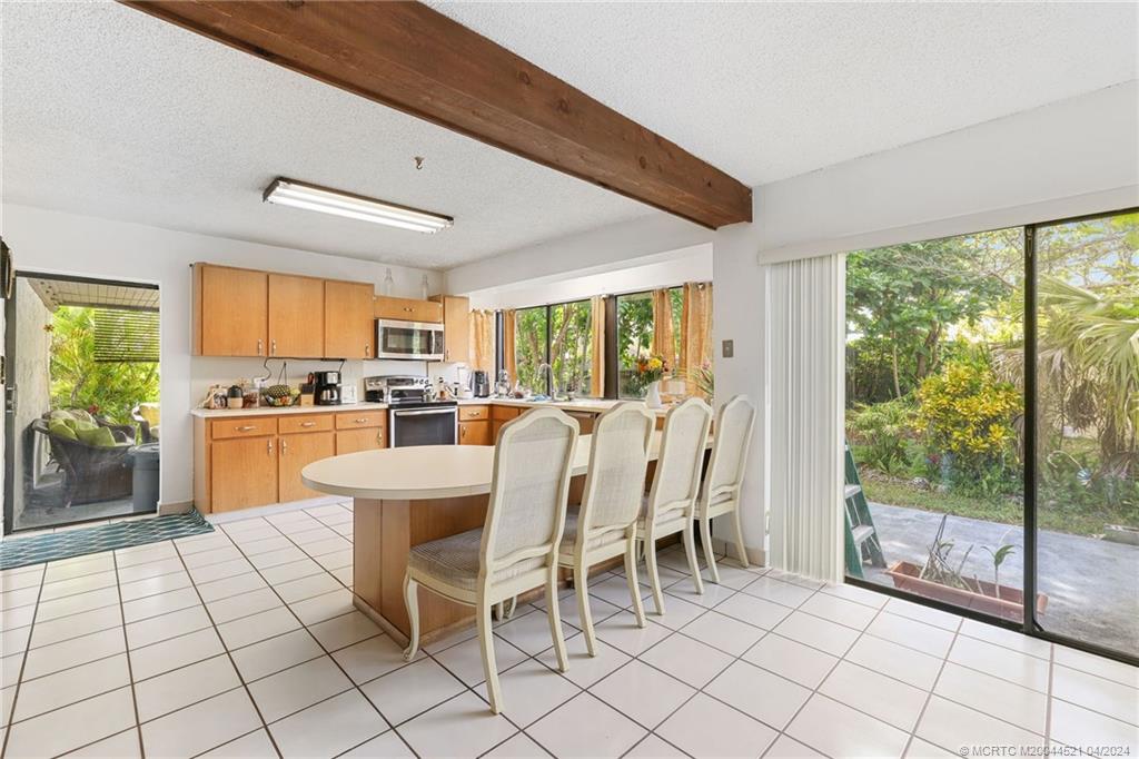 12775 Southwest 110th Terrace Miami, FL 33186 - Photo 13 of 36 a dining room with stainless steel appliances a large window and a view of kitchen