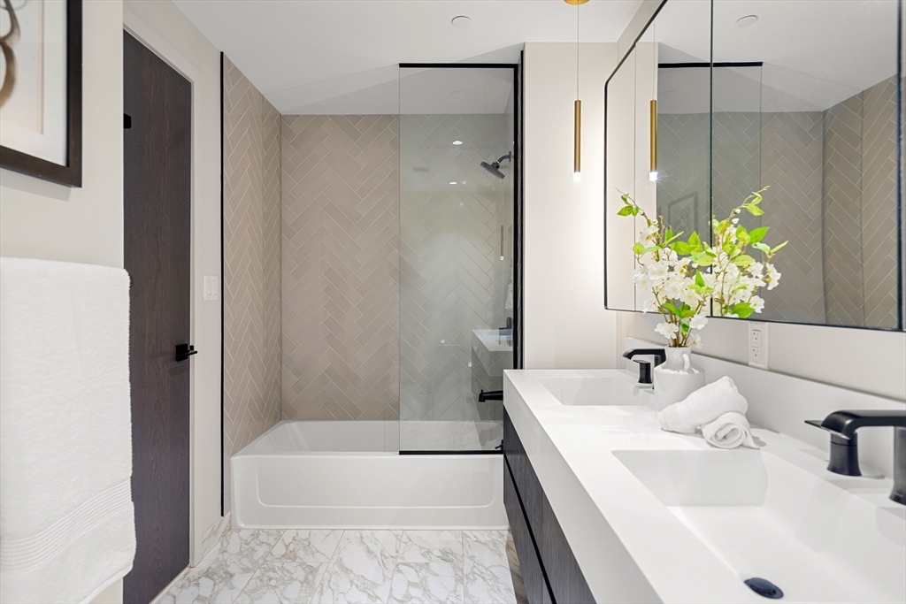 55 Lagrange Street, Unit 1901 Boston, MA 02111 - Photo 20 of 34 a bathroom with a tub sink and mirror