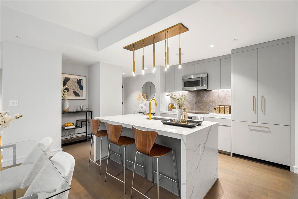 55 Lagrange Street, Unit 1901 Boston, MA 02111 - Photo 5 of 34 a kitchen with kitchen island a stove a sink and a refrigerator