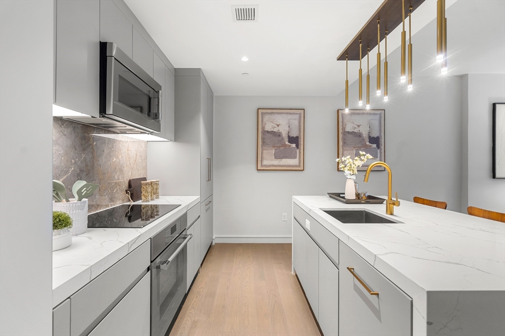 55 Lagrange Street, Unit 1901 Boston, MA 02111 - Photo 6 of 34 a kitchen with stainless steel appliances granite countertop a sink and a stove