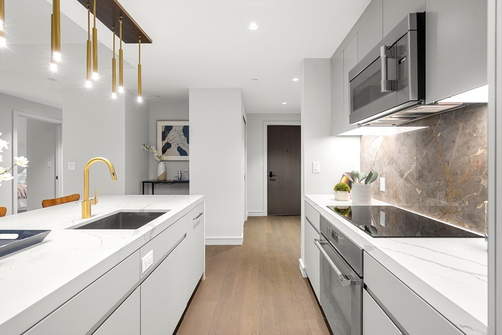 55 Lagrange Street, Unit 1901 Boston, MA 02111 - Photo 7 of 34 a kitchen with granite countertop a sink and cabinets