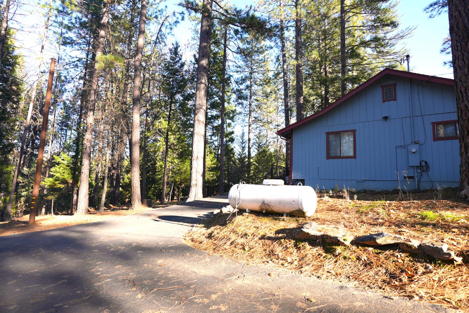23625 Rock Hammer Road Groveland, CA 95321 - Photo 36 of 40 a backyard of a house with large trees and wooden fence