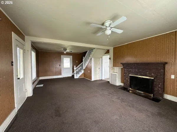 a view of a livingroom with a fireplace and ceiling fan