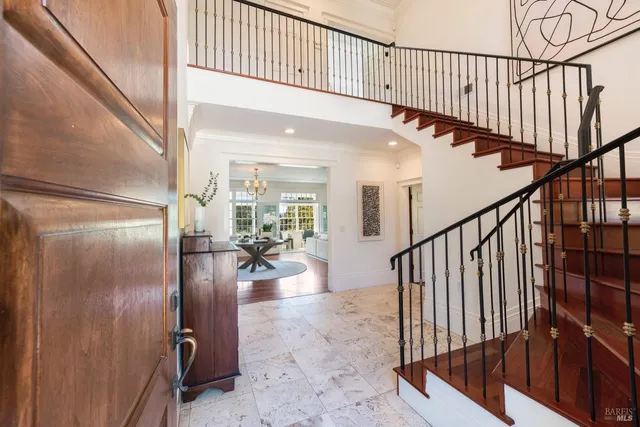 a view of staircase with lots of frames on wall and windows