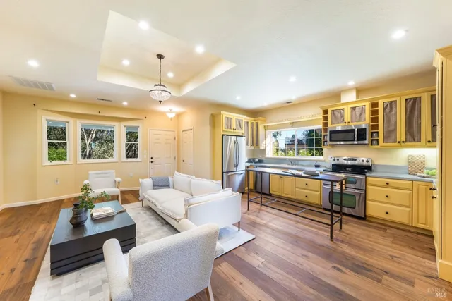 a living room with stainless steel appliances kitchen island granite countertop furniture and a kitchen view