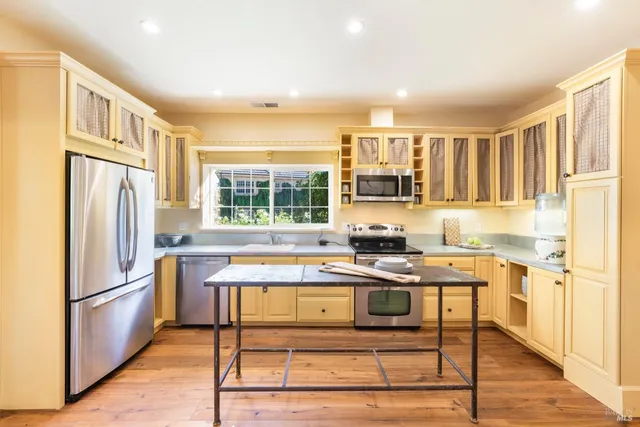 a kitchen with stainless steel appliances granite countertop a stove a refrigerator and a cabinets
