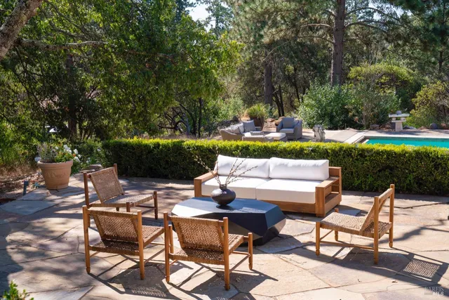 a view of patio with table and chairs potted plants and tree