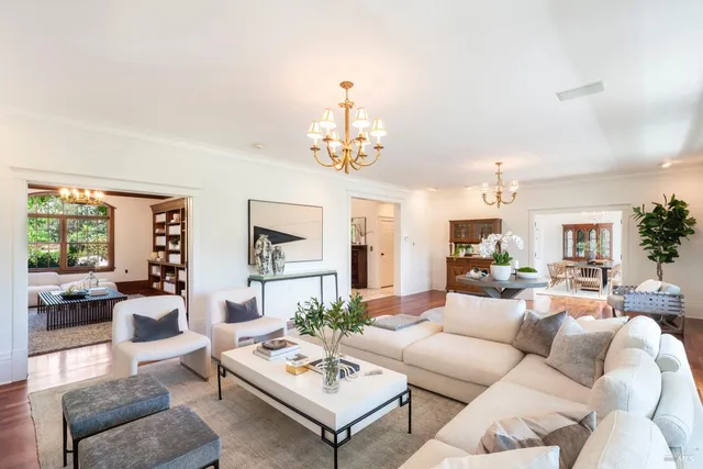 a living room with furniture a chandelier and a large window