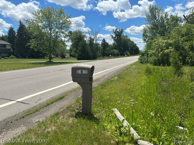 30600 Fort Road Rockwood, MI 48173 - Photo 7 of 28 Roadside mailbox with visible address numbers 360, set against a backdrop of mature trees and a clear blue sky with white clouds
