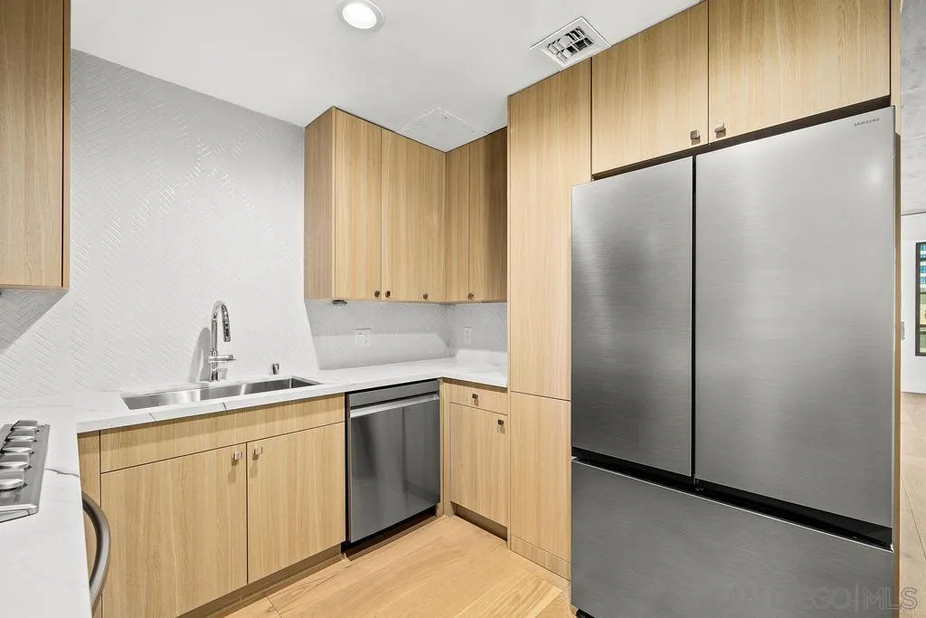 801 Ash Street, Unit 402 San Diego, CA 92101 - Photo 11 of 31 a kitchen with a sink appliances and cabinets