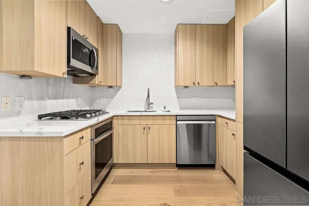 801 Ash Street, Unit 402 San Diego, CA 92101 - Photo 12 of 31 a kitchen with stainless steel appliances granite countertop a stove a sink and a microwave