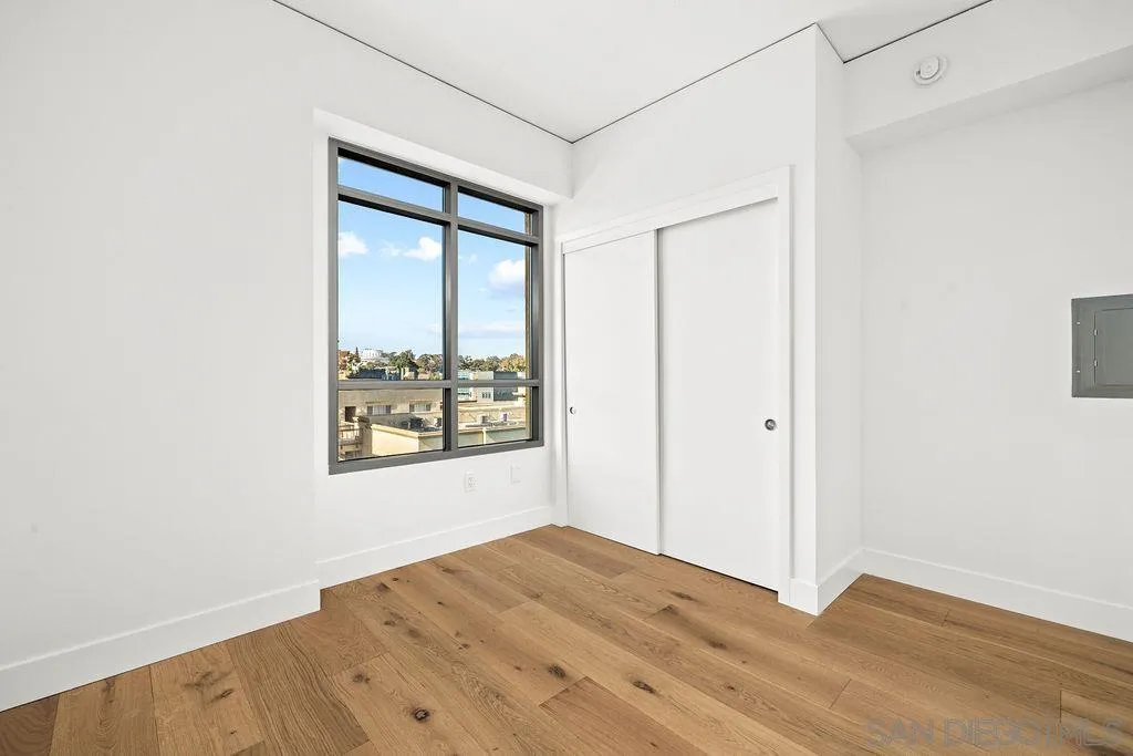 801 Ash Street, Unit 402 San Diego, CA 92101 - Photo 24 of 31 an empty room with wooden floor and windows
