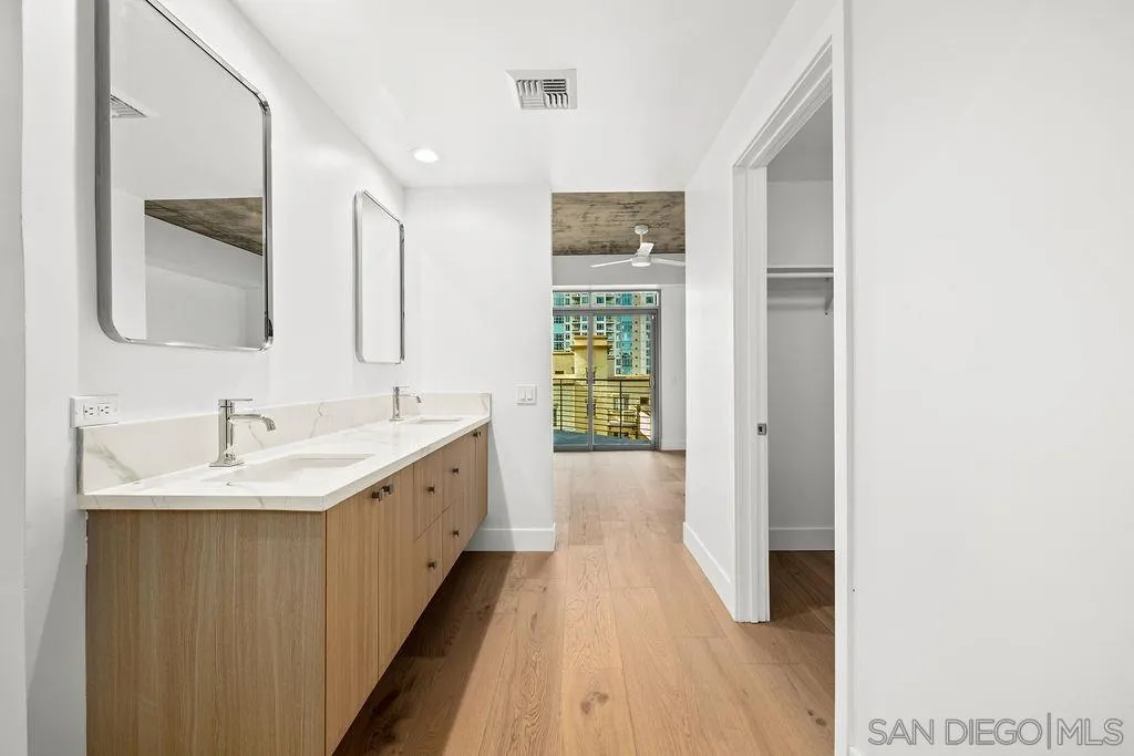 801 Ash Street, Unit 402 San Diego, CA 92101 - Photo 30 of 31 a spacious bathroom with a double vanity sink and a mirror