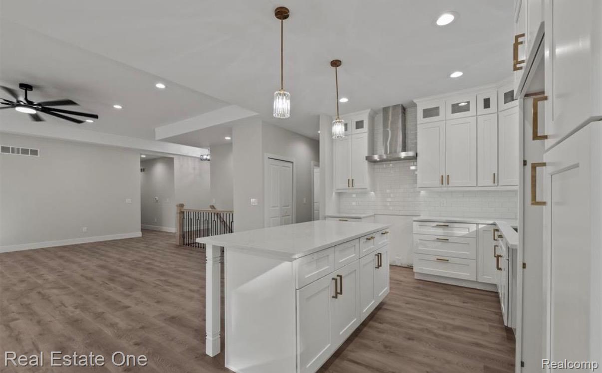 5636 Paris Street Sterling Heights, MI 48310 - Photo 37 of 37 Kitchen featuring white cabinetry, a kitchen island, dark wood finished floors, open floor plan, and glass insert cabinets