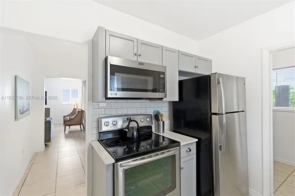 a kitchen with stainless steel appliances granite countertop a refrigerator stove a sink and a microwave