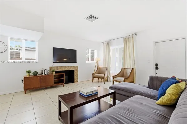 a living room with furniture a fireplace and a flat screen tv