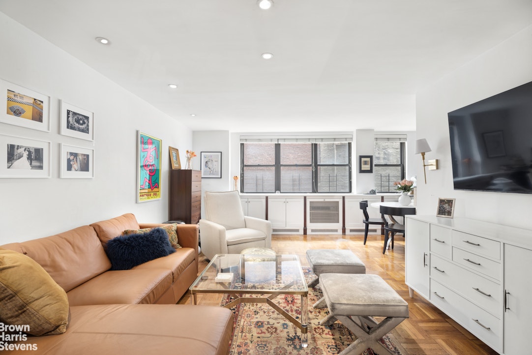 239 East 79th Street, Unit 2M Manhattan, NY 10075 - Photo 1 of 10 a living room with furniture and a flat screen tv