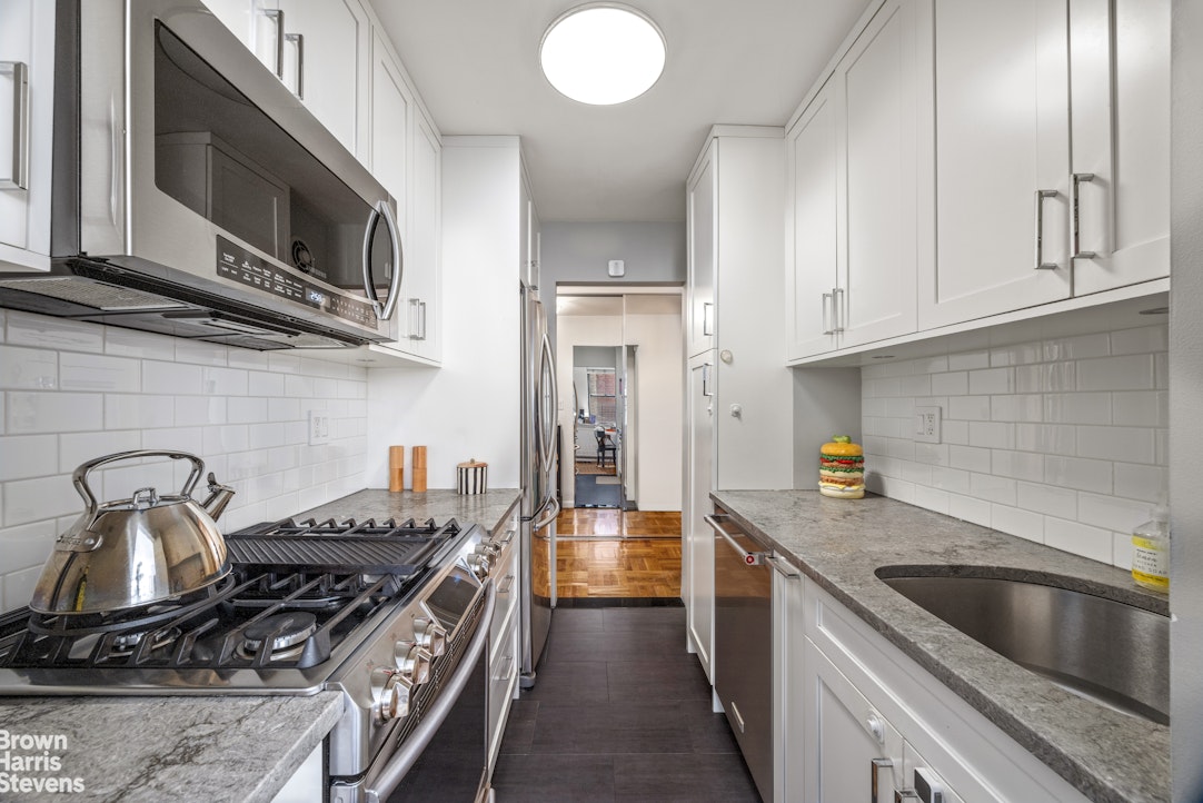 239 East 79th Street, Unit 2M Manhattan, NY 10075 - Photo 4 of 10 a kitchen with stainless steel appliances granite countertop a stove and a sink