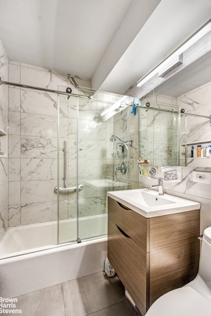 239 East 79th Street, Unit 2M Manhattan, NY 10075 - Photo 6 of 10 a bathroom with a sink toilet and shower