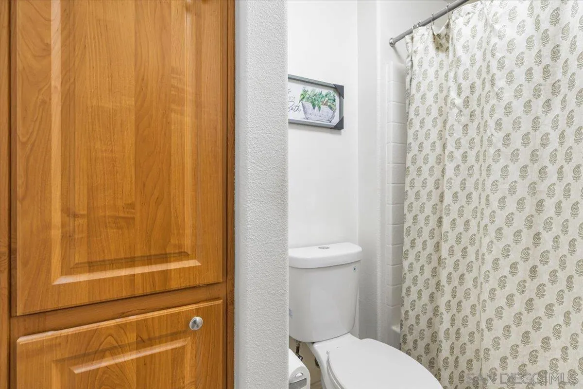 2715 Lake Pointe Drive, Unit 116 Spring Valley, CA 91977 - Photo 13 of 25 a white toilet sitting next to a shower curtain