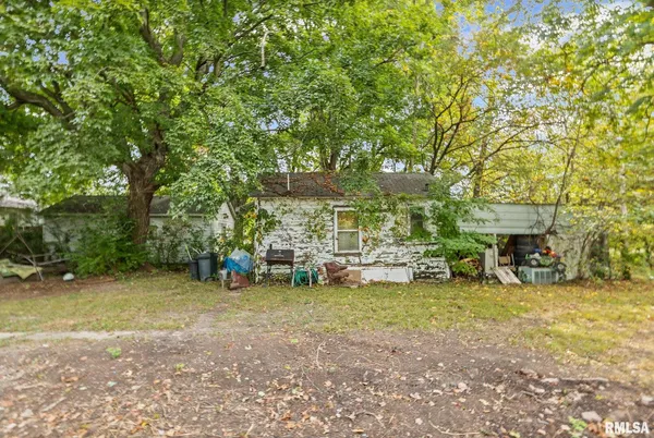 a view of a backyard with table and chairs and a large tree