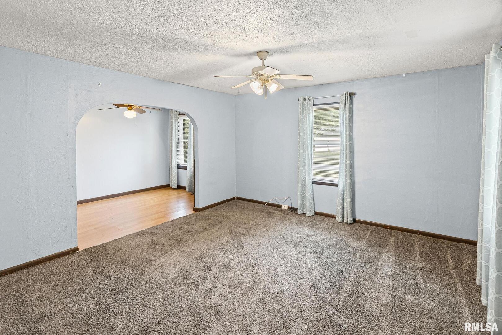 721 West Whittaker Street Salem, IL 62881 - Photo 5 of 25 an empty room with chandelier fan and windows