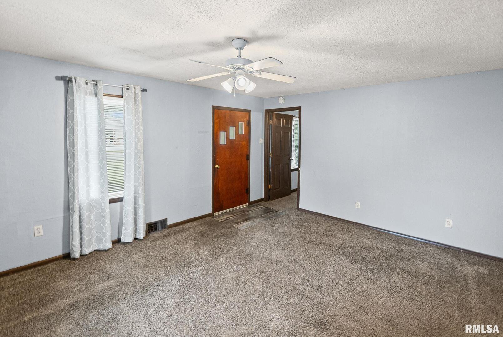 721 West Whittaker Street Salem, IL 62881 - Photo 8 of 25 a view of an empty room with a ceiling fan