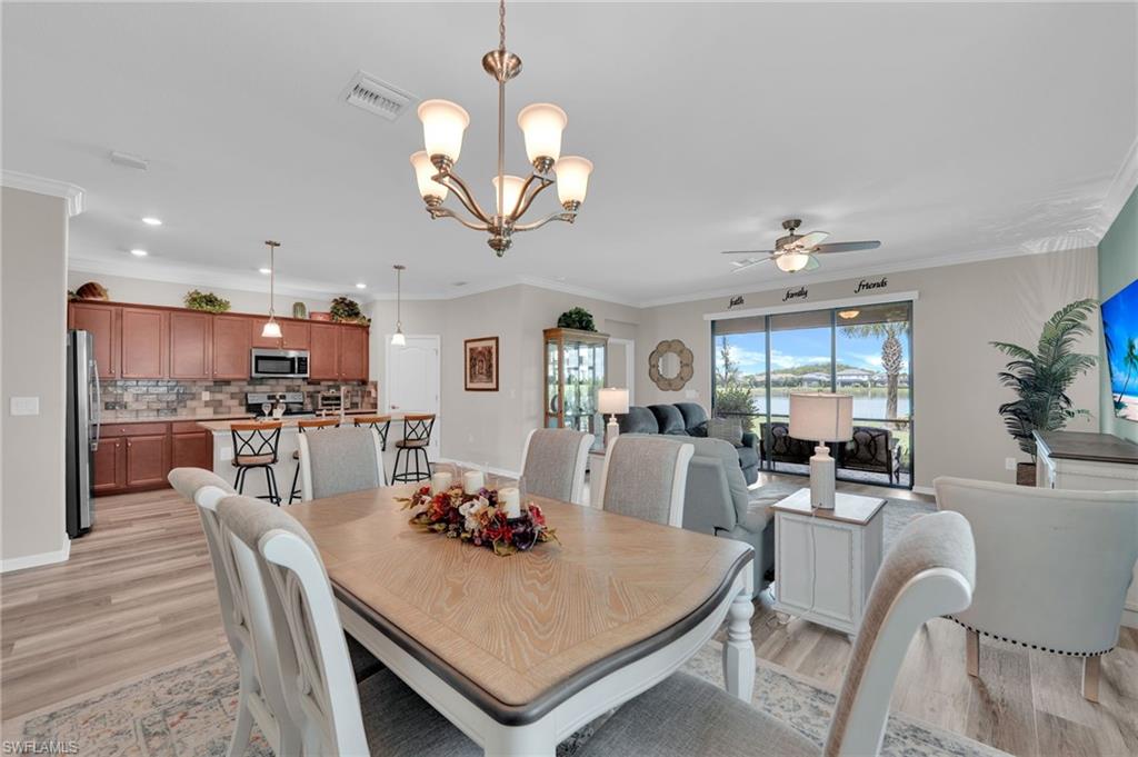 19565 Deming Lane Estero, FL 33928 - Photo 14 of 43 a view of a dining room with furniture a chandelier and wooden floor