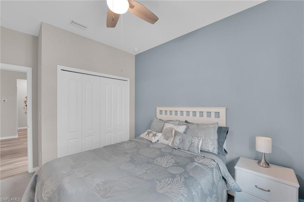 19565 Deming Lane Estero, FL 33928 - Photo 16 of 43 a bedroom with a bed and a chandelier