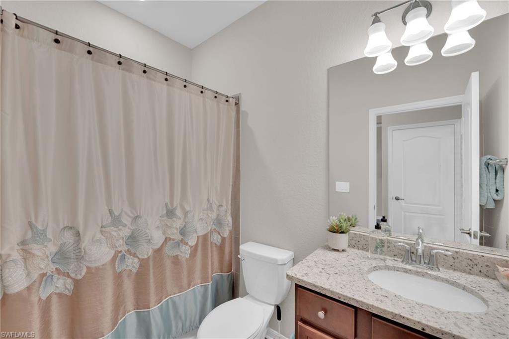 19565 Deming Lane Estero, FL 33928 - Photo 19 of 43 a bathroom with a granite countertop sink a toilet and a mirror