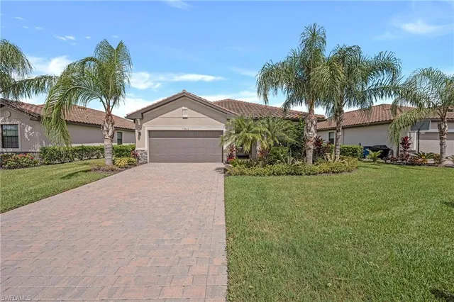 a front view of a house with a garden and palm trees