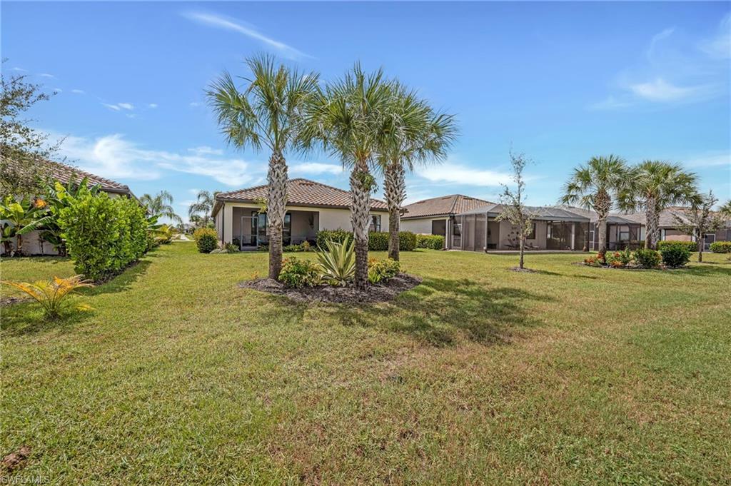 19565 Deming Lane Estero, FL 33928 - Photo 7 of 43 a front view of a house with garden and trees