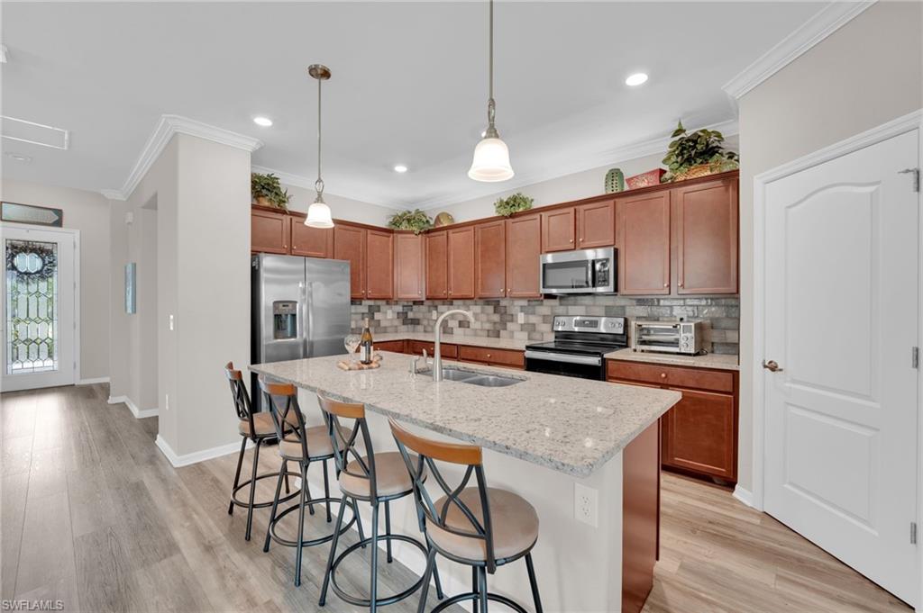 19565 Deming Lane Estero, FL 33928 - Photo 9 of 43 a kitchen with granite countertop a center island a sink cabinets and stainless steel appliances