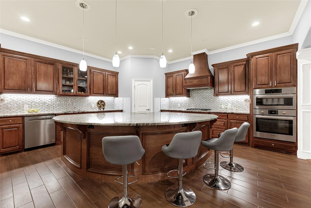2613 Ranch Court Cedar Hill, TX 75104 - Photo 4 of 29 a kitchen with stainless steel appliances granite countertop wooden cabinets a sink a stove a dining table and chairs
