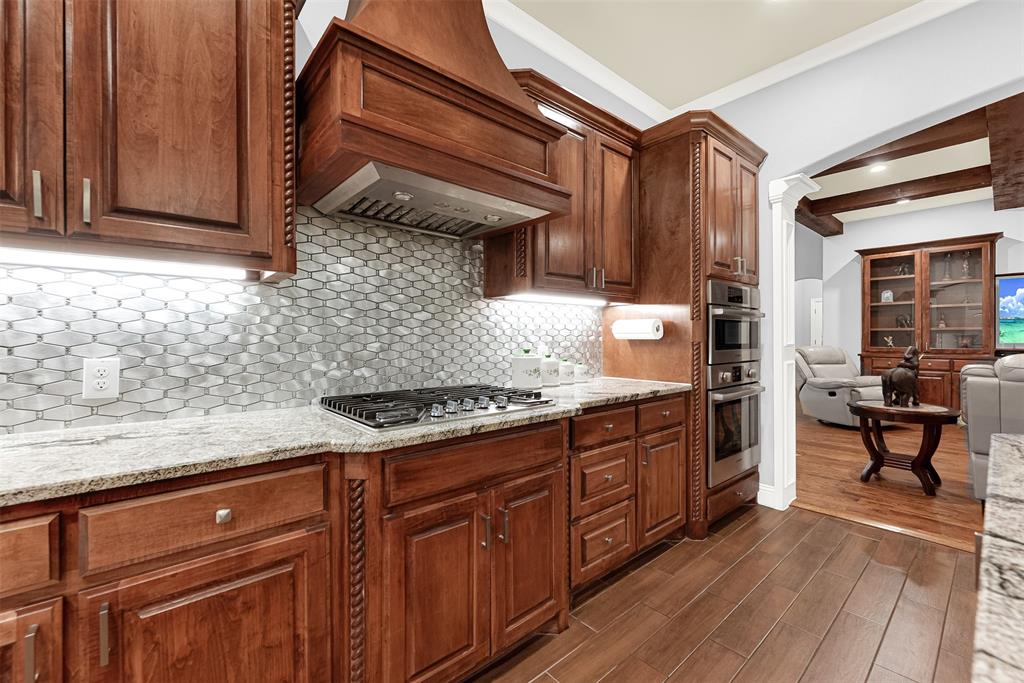 2613 Ranch Court Cedar Hill, TX 75104 - Photo 10 of 29 a kitchen with granite countertop wooden cabinets and a stove top oven