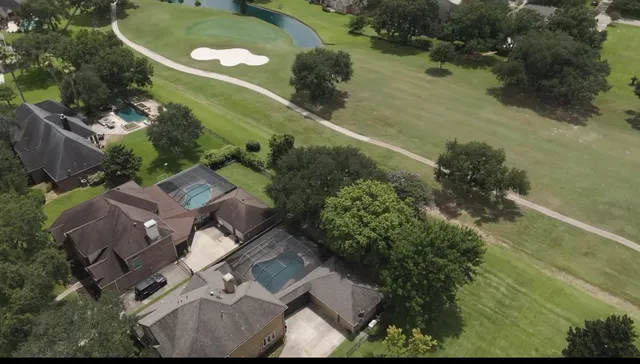 an aerial view of a house with a yard and lake view