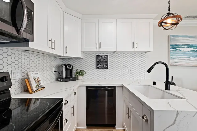 a kitchen with stainless steel appliances granite countertop a sink a stove and cabinets