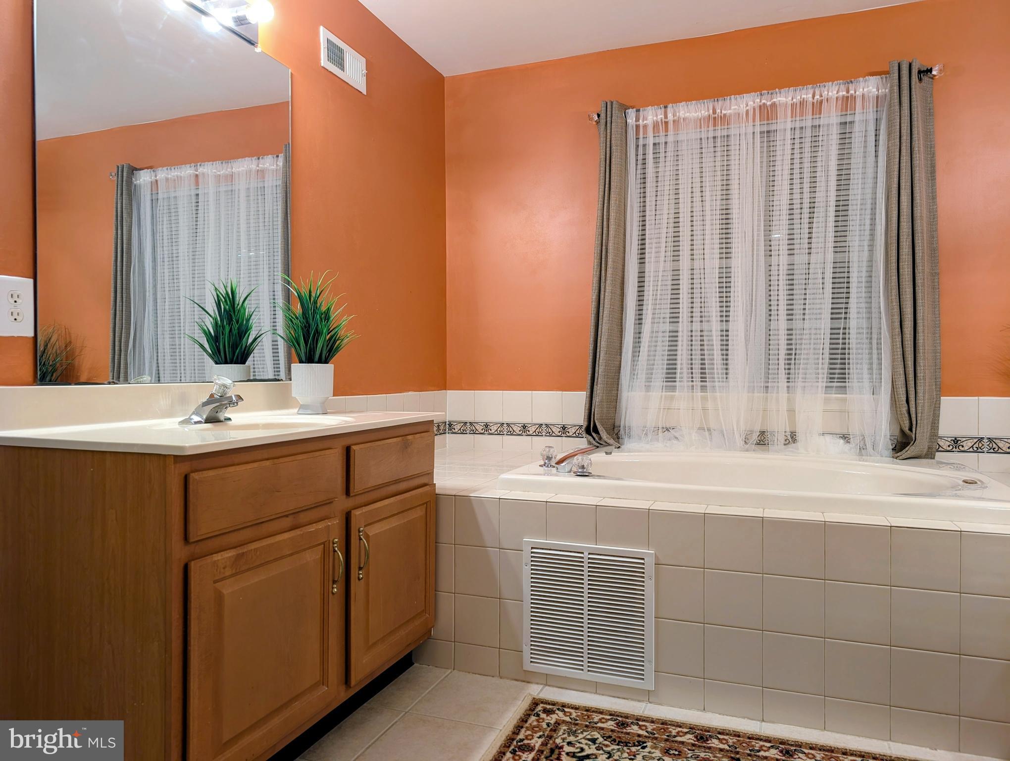 21 Miller Circle Pennington, NJ 08534 - Photo 8 of 14 a bathroom with a double vanity sink a mirror and a bathtub