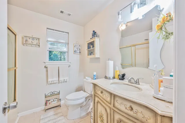 a bathroom with a granite countertop sink a toilet and a mirror