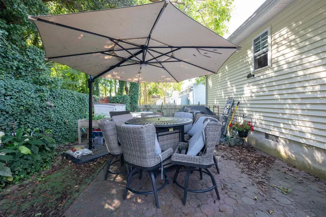a view of a patio with table and chairs under an umbrella