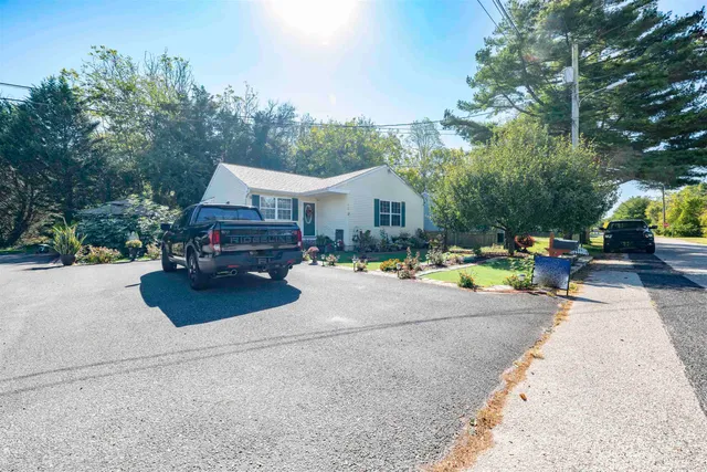 front view of a house with a yard and a garden